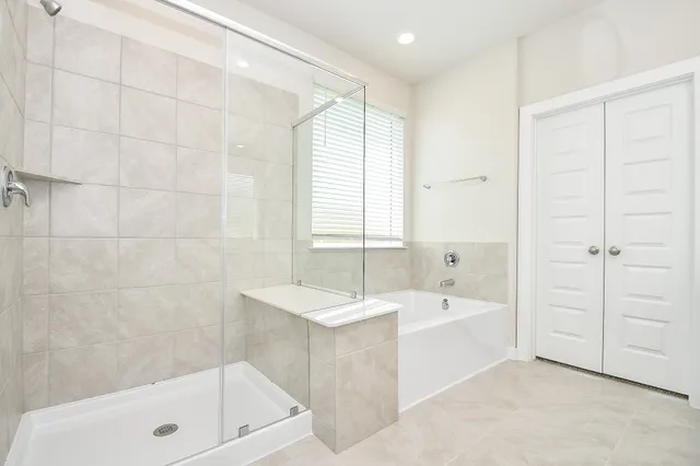 a bathroom with a bathtub a shower a sink and a window