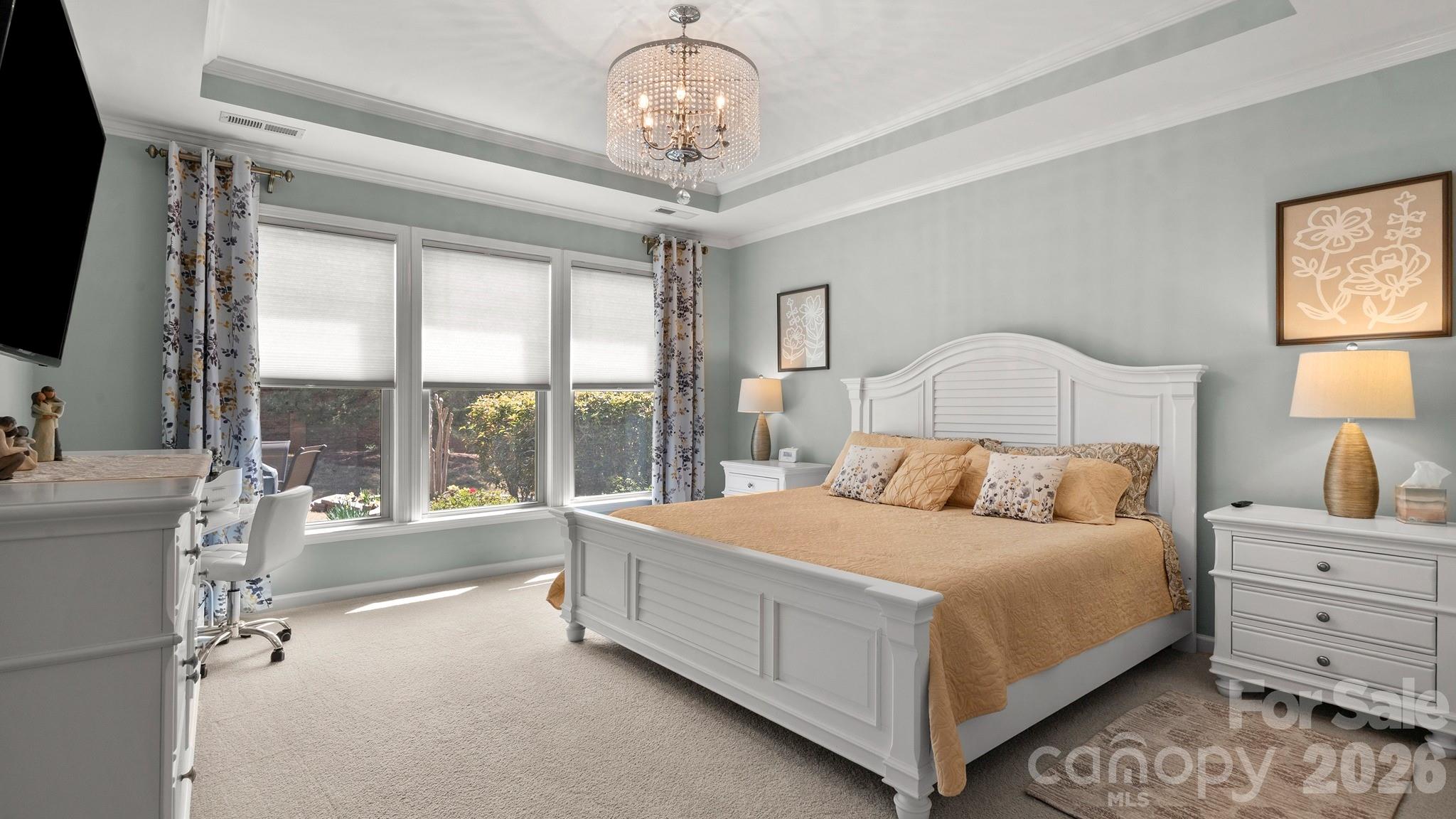 952 Kirby Drive Fort Mill, SC 29715 - Photo 15 of 42 a bedroom with a large bed and a chandelier