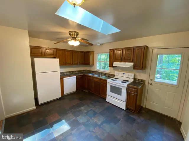 a kitchen with stainless steel appliances granite countertop a refrigerator a stove a sink and a microwave