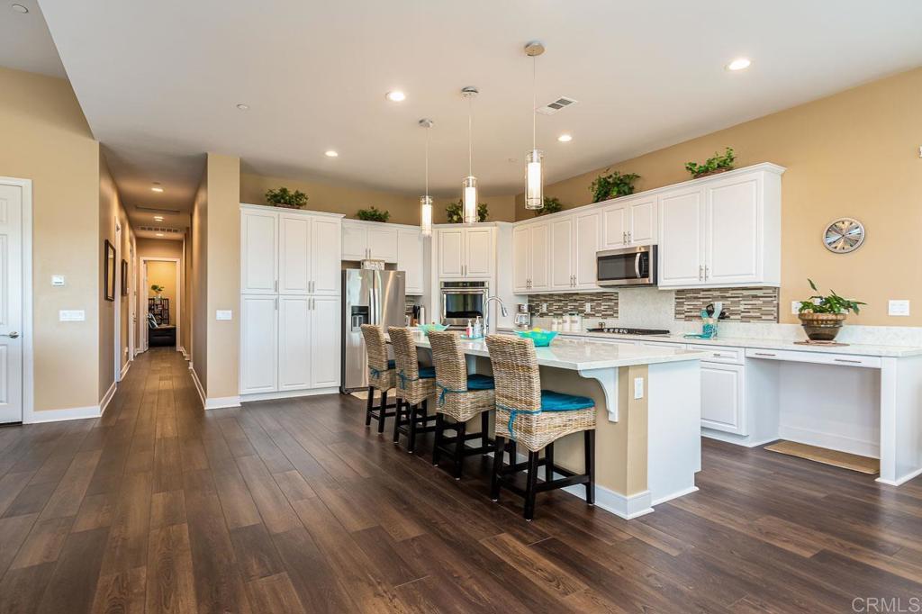 1194 Palomar Circle Escondido, CA 92027 - Photo 3 of 37 a kitchen with white cabinets and stainless steel appliances