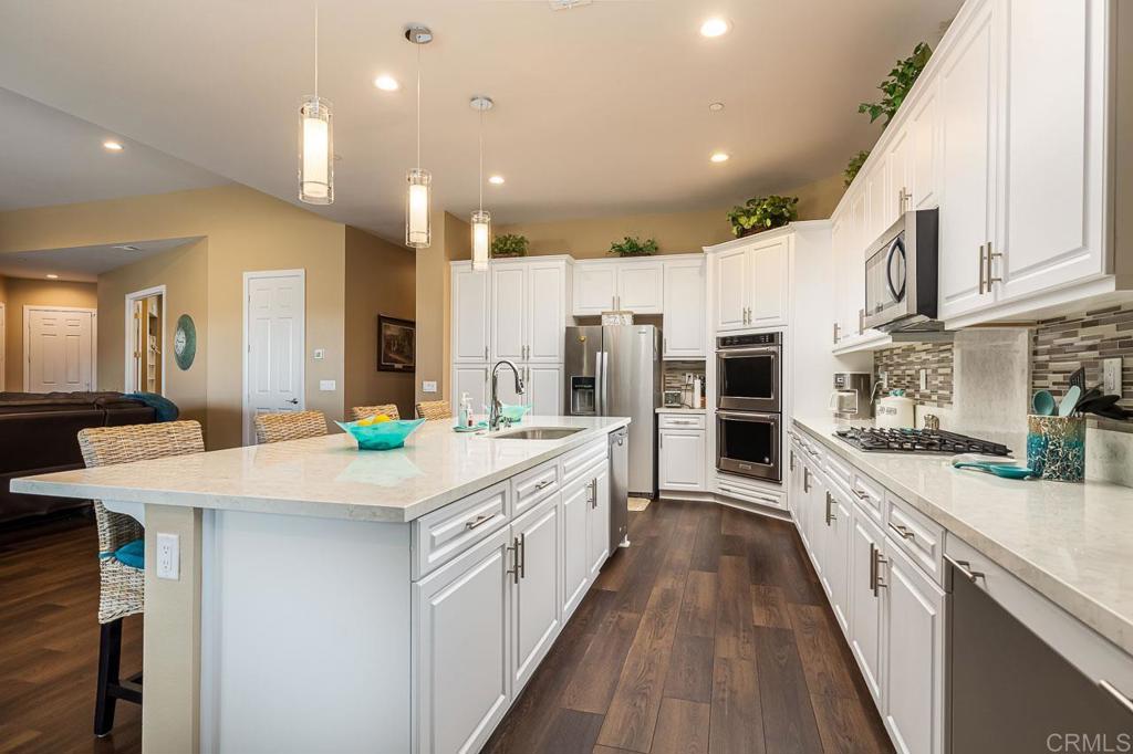 1194 Palomar Circle Escondido, CA 92027 - Photo 5 of 37 a large kitchen with stainless steel appliances kitchen island a large counter top a stove and a sink