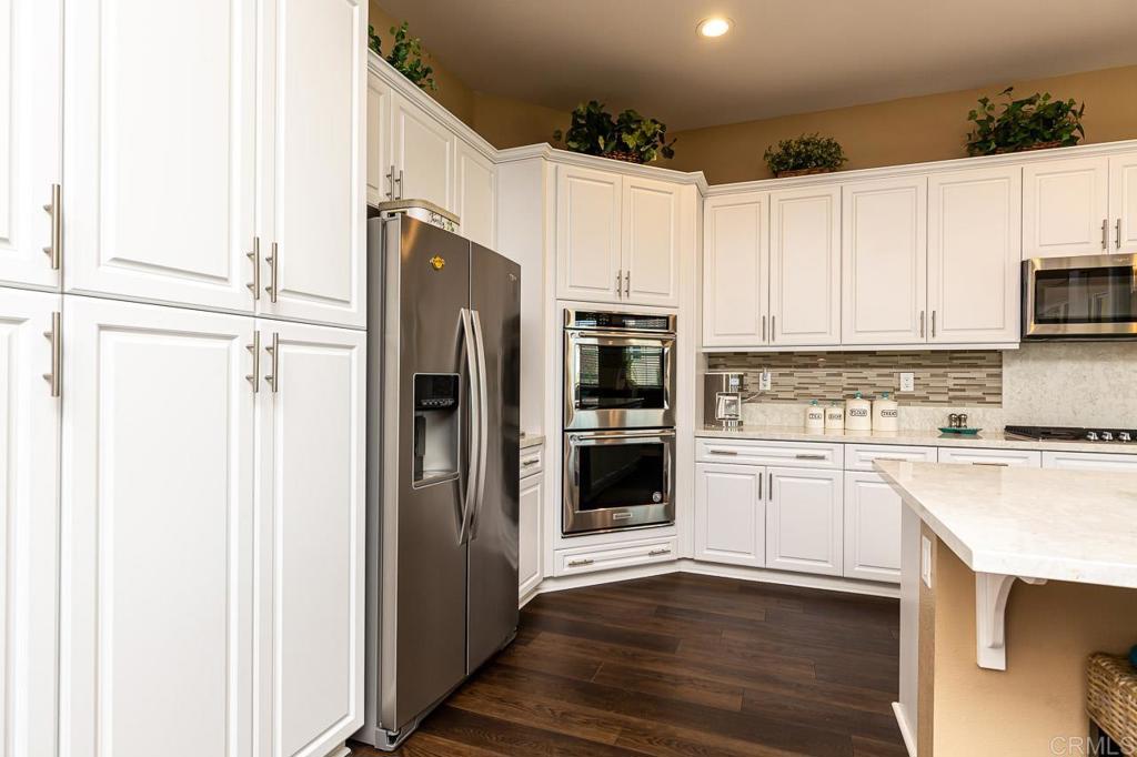 1194 Palomar Circle Escondido, CA 92027 - Photo 6 of 37 a kitchen with granite countertop white cabinets and stainless steel appliances