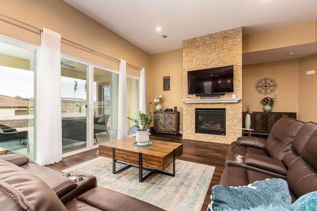 1194 Palomar Circle Escondido, CA 92027 - Photo 7 of 37 a living room with furniture a flat screen tv and a fireplace