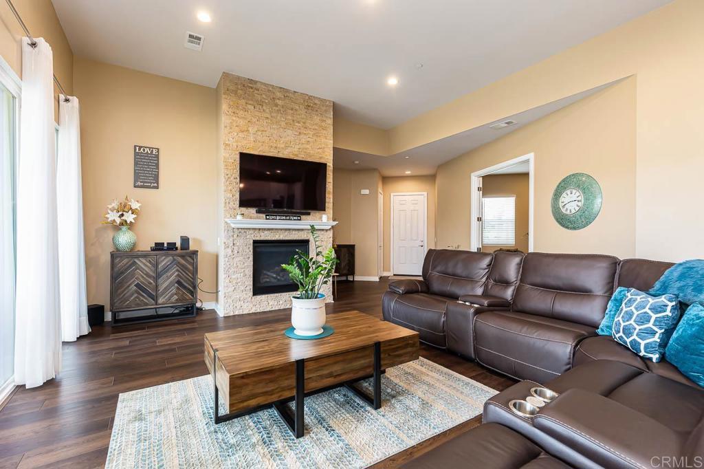 1194 Palomar Circle Escondido, CA 92027 - Photo 8 of 37 a living room with furniture a flat screen tv and a fireplace