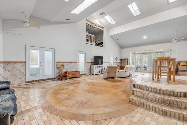 a kitchen with stainless steel appliances granite countertop a refrigerator a stove a sink a dining table and chairs with wooden floor