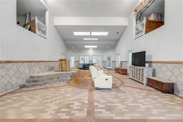 a kitchen with stainless steel appliances granite countertop a refrigerator a sink dishwasher and white cabinets with wooden floor