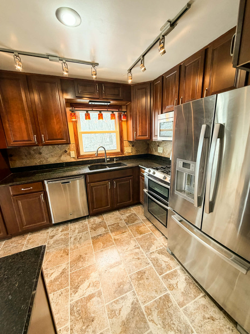 2211 613th Avenue Sabula, IA 52070 - Photo 11 of 45 a kitchen with granite countertop a refrigerator and sink