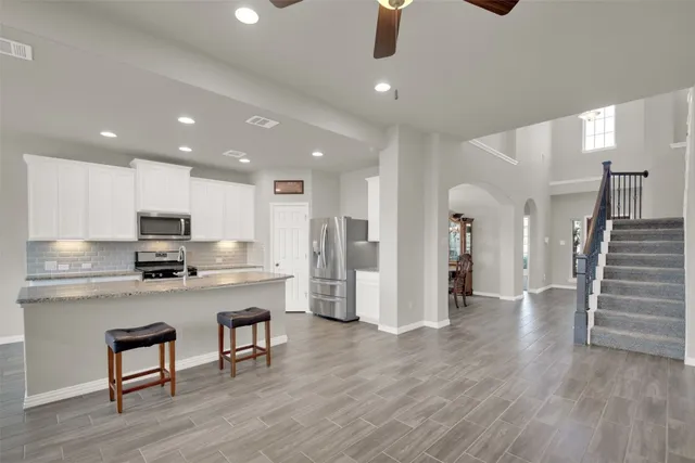 a view of kitchen with refrigerator microwave and wooden floor