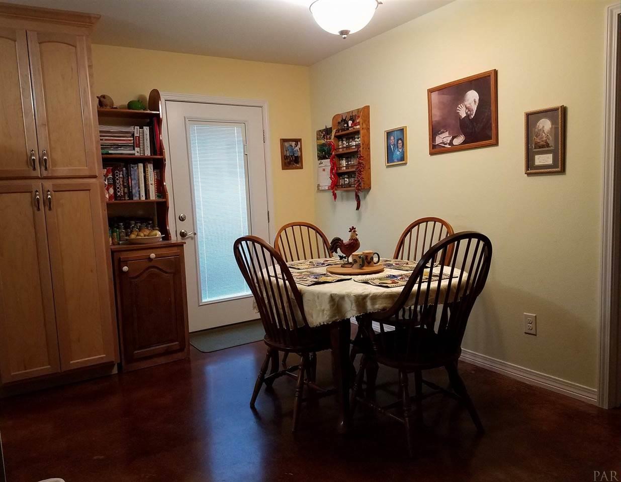 4708 Old Guernsey Road Pace, FL 32571 - Photo 15 of 46 a view of a dining room with furniture and wooden floor