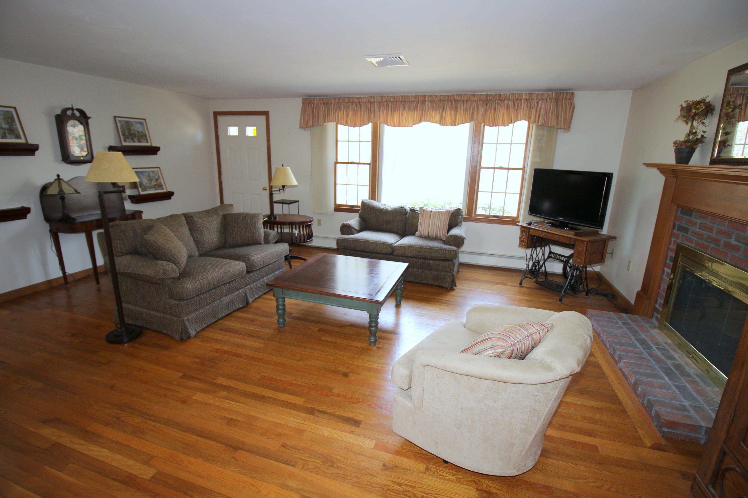 9 Gates Path Dennis, MA 02638 - Photo 3 of 20 a living room with furniture flat screen tv and a fireplace
