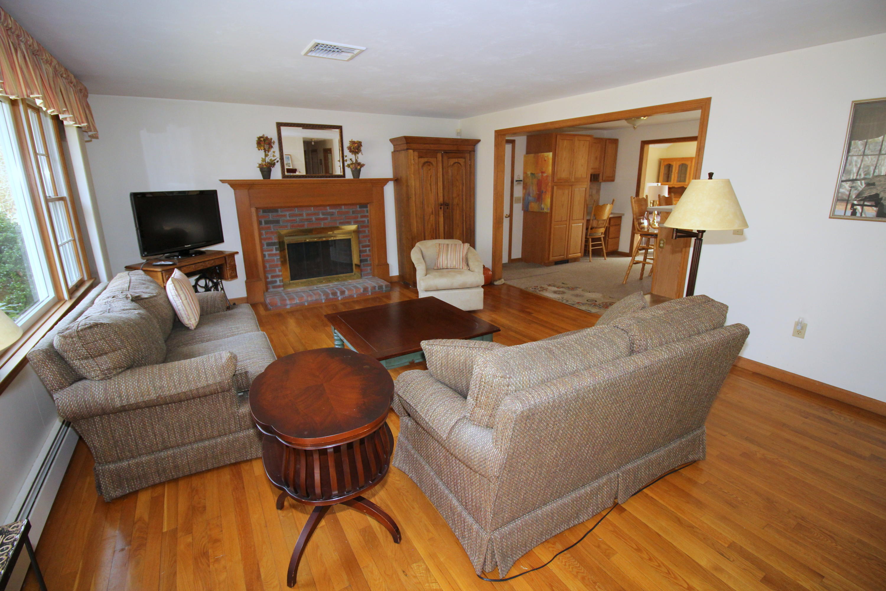 9 Gates Path Dennis, MA 02638 - Photo 4 of 20 a living room with furniture a flat screen tv and a fireplace