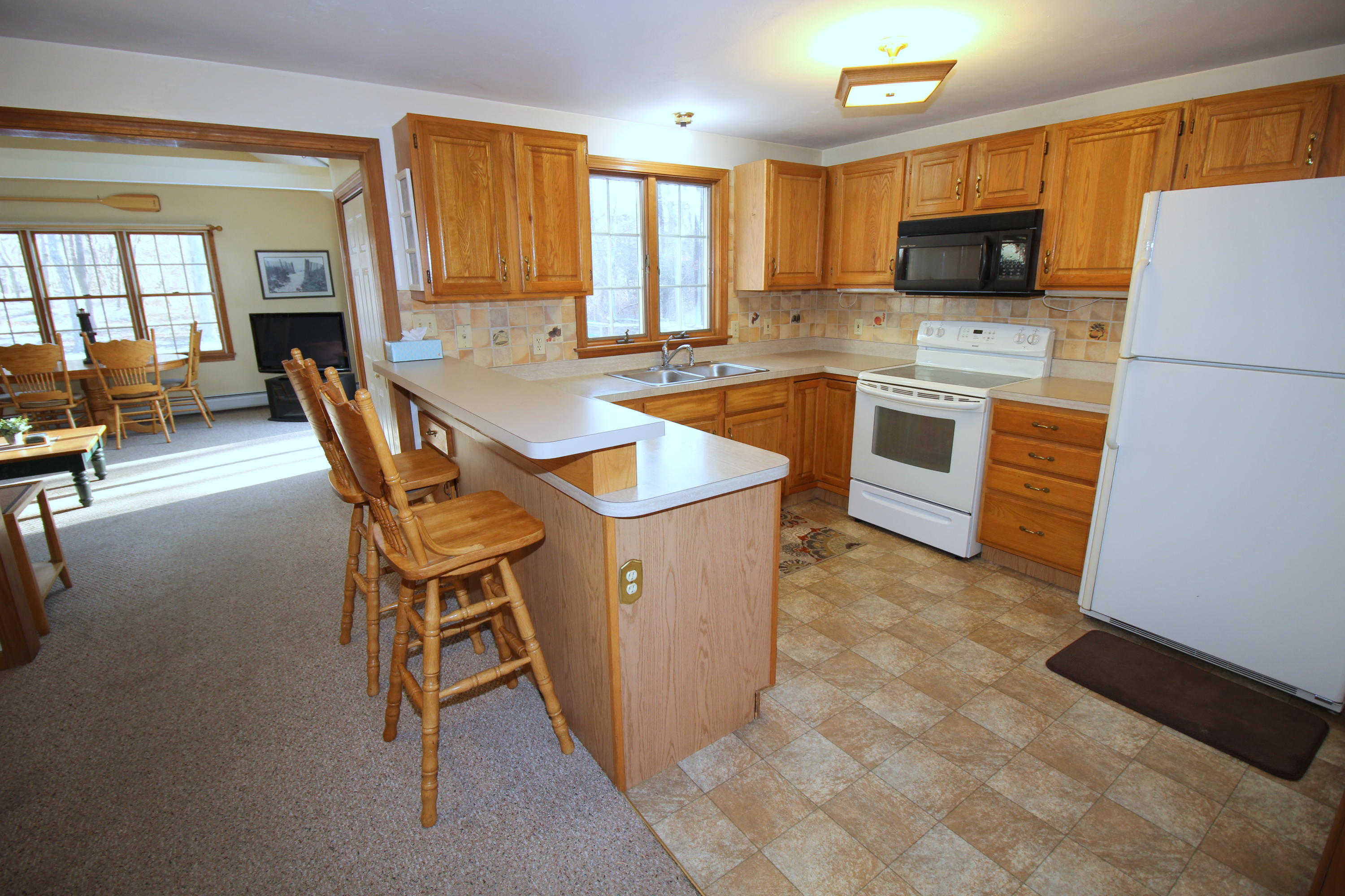 9 Gates Path Dennis, MA 02638 - Photo 7 of 20 a kitchen with a refrigerator a stove top oven a sink dishwasher and white cabinets with wooden floor