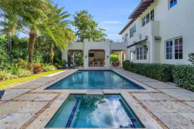 a front view of a house with a yard and potted plants