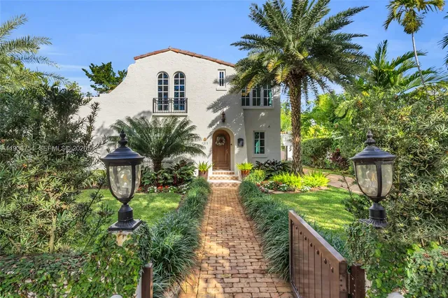 a front view of multi story residential apartment building with yard and green space