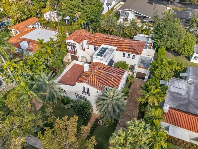 front view of house with a yard and trees