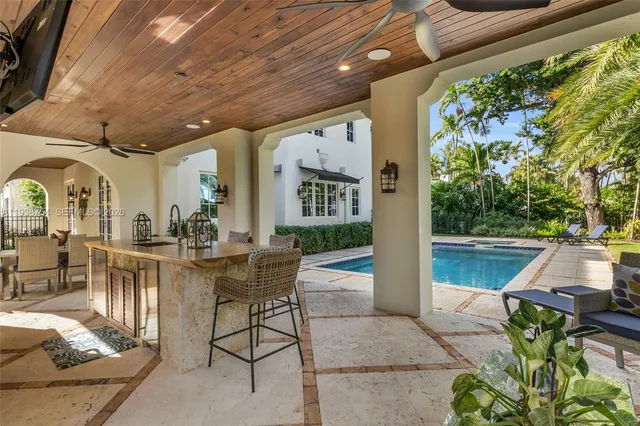 a view of a patio with table and chairs potted plants with floor to ceiling window and potted plants