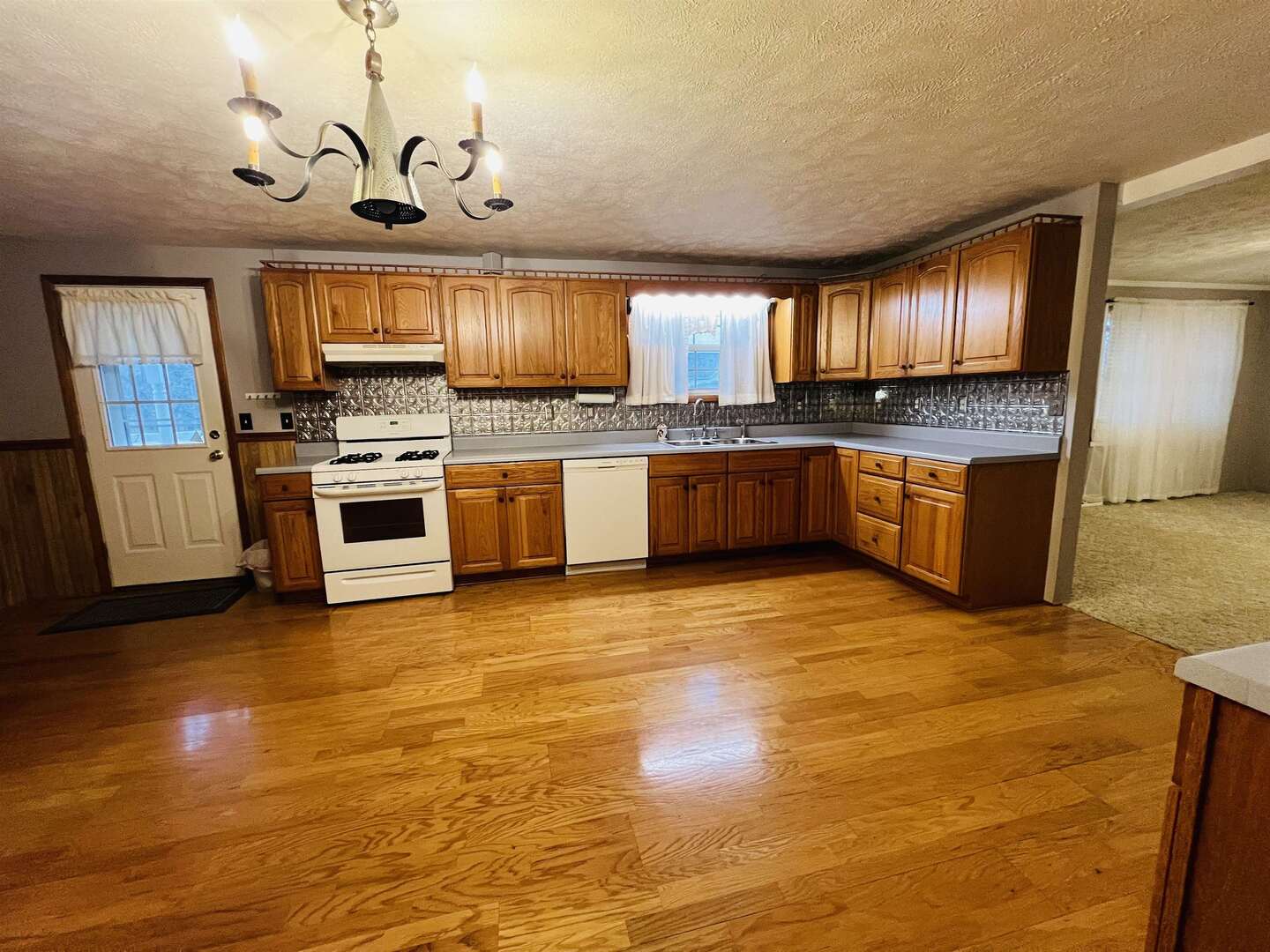 191 West Davis Street Equality, IL 62934 - Photo 11 of 21 a large kitchen with granite countertop a stove top oven a sink dishwasher a dining table and chairs with wooden floor