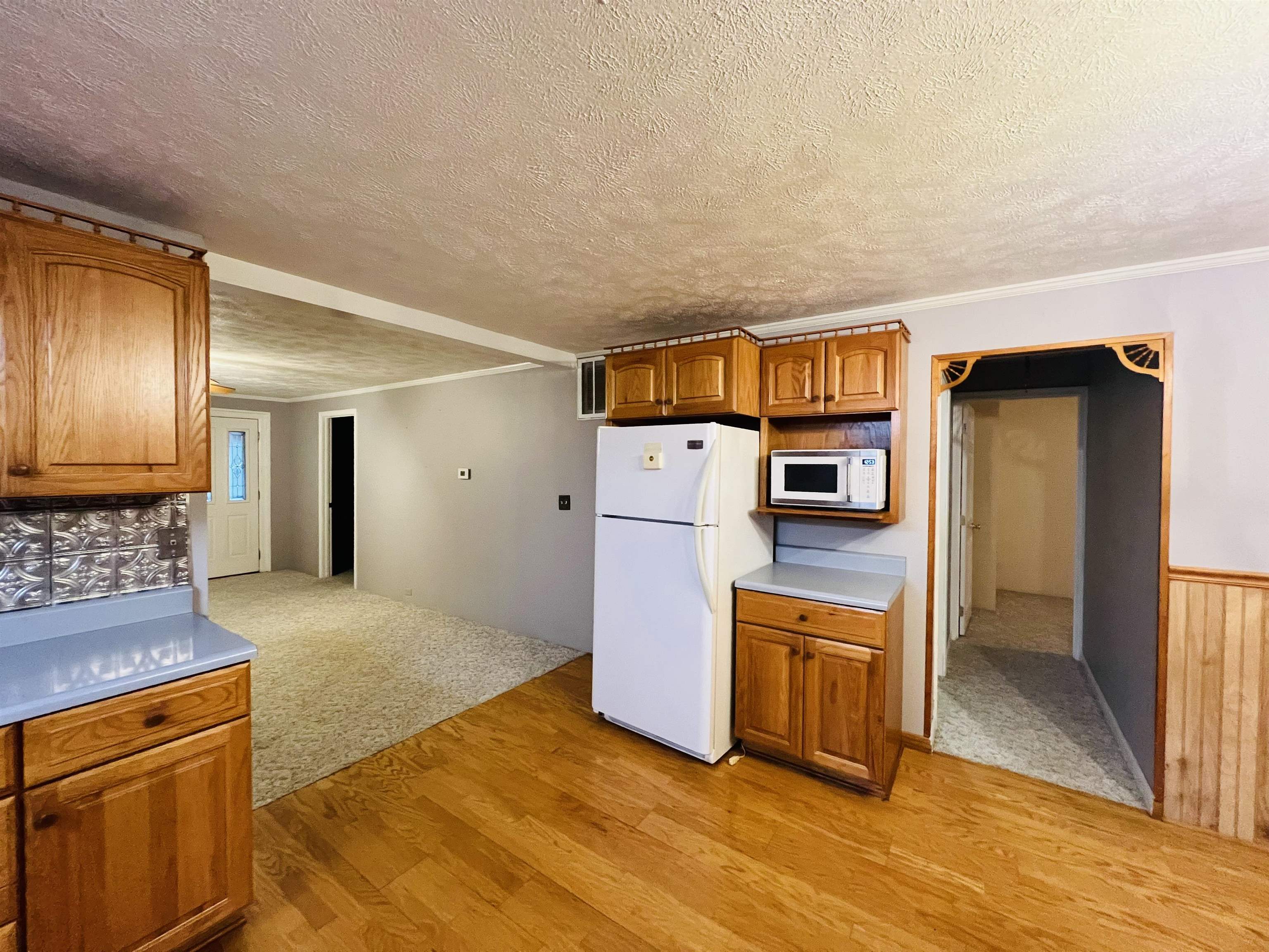 191 West Davis Street Equality, IL 62934 - Photo 12 of 21 a kitchen with stainless steel appliances granite countertop a refrigerator a stove and a sink with wooden floors