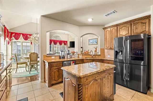 a kitchen with stainless steel appliances granite countertop a refrigerator and a sink