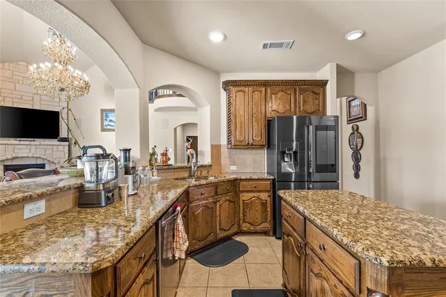 a kitchen with granite countertop a sink stove and refrigerator