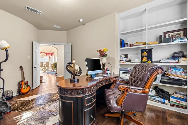 a work room with furniture a rug and a bookshelf