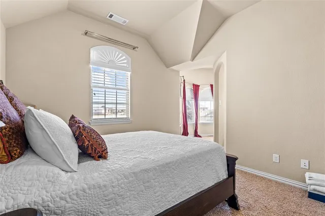 a bed sitting in a bedroom next to a window