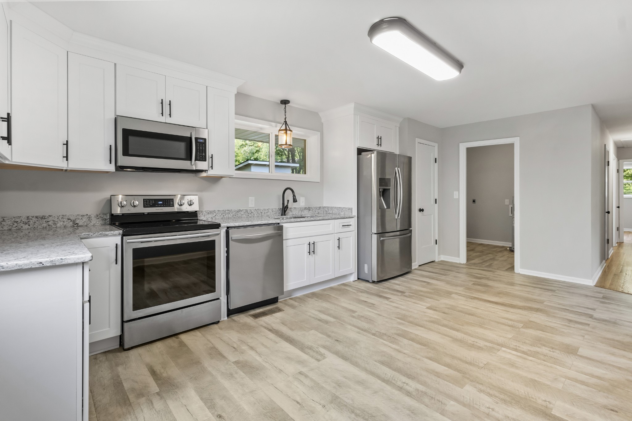 a kitchen with stainless steel appliances granite countertop a stove a refrigerator and a microwave