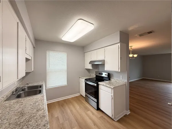 a kitchen with granite countertop a stove and a sink