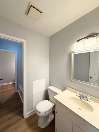 a bathroom with a sink a toilet a mirror and vanity