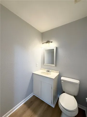 a bathroom with a toilet a sink a mirror and vanity