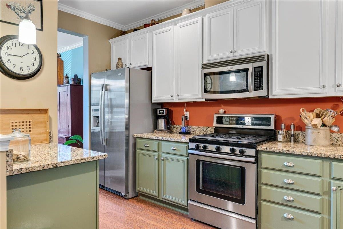 2924 Casona Way Raleigh, NC 27616 - Photo 5 of 21 a kitchen with stainless steel appliances granite countertop a stove and a microwave