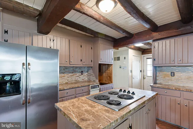 a kitchen with stainless steel appliances granite countertop a sink refrigerator and cabinets
