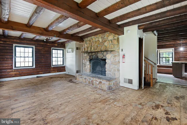 a view of an empty room with window and fireplace