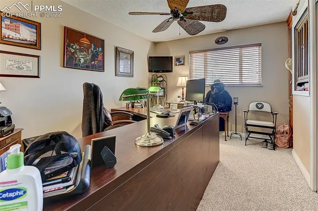 a work room with furniture a flat screen tv and a window