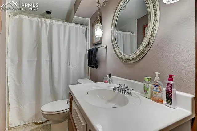a bathroom with a sink a toilet and a mirror
