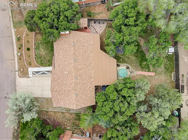 an aerial view of a house with a yard and large trees