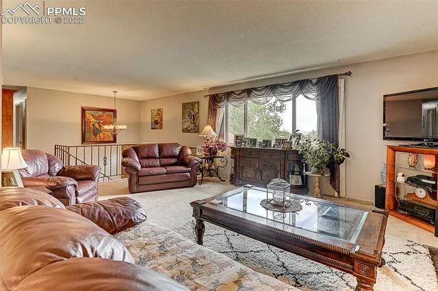 a living room with furniture large window and a table