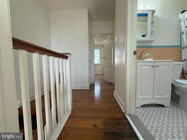 a view of a hallway with wooden floor and closet