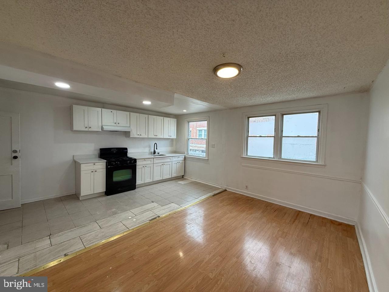 1243 Hellerman Street Philadelphia, PA 19111 - Photo 5 of 20 a kitchen with stainless steel appliances granite countertop a stove a sink and a refrigerator with wooden floors