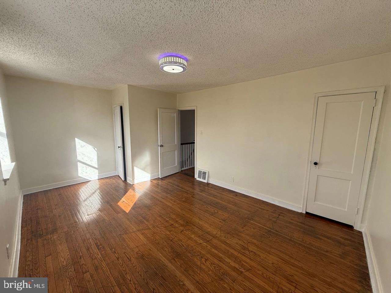 1243 Hellerman Street Philadelphia, PA 19111 - Photo 10 of 20 a view of an empty room with wooden floor and a window