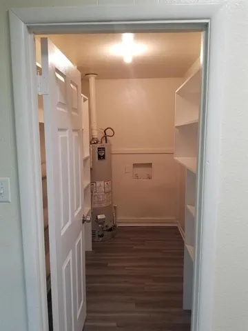 a view of a livingroom with wooden floor and a hallway