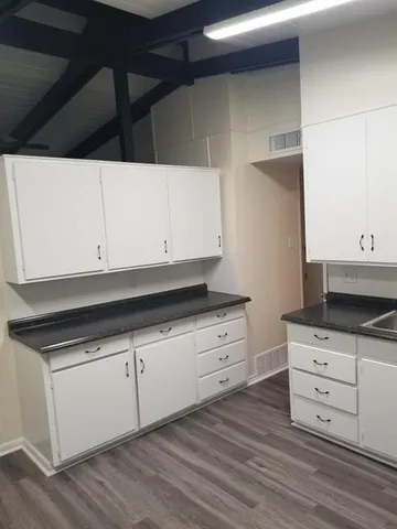 a kitchen with granite countertop white cabinets and white appliances