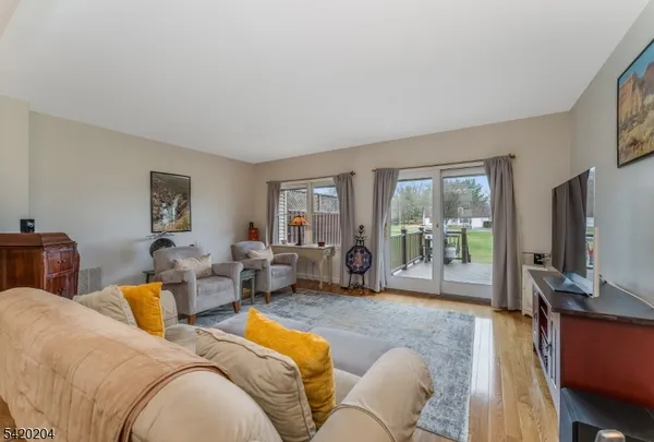 a living room with furniture large window and a flat screen television