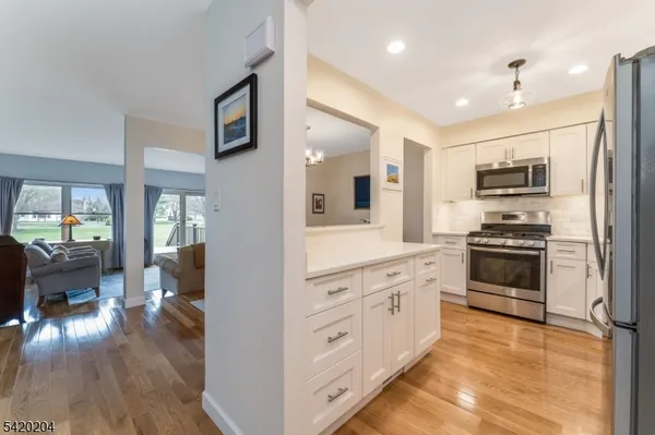 a kitchen with stainless steel appliances kitchen island granite countertop a stove top oven a sink and a refrigerator