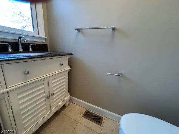 a bathroom with a sink toilet and window