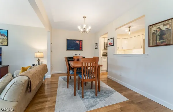 a dining room with wooden floor and chandelier