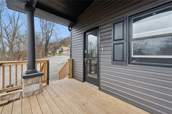 a view of a balcony with wooden floor and furniture