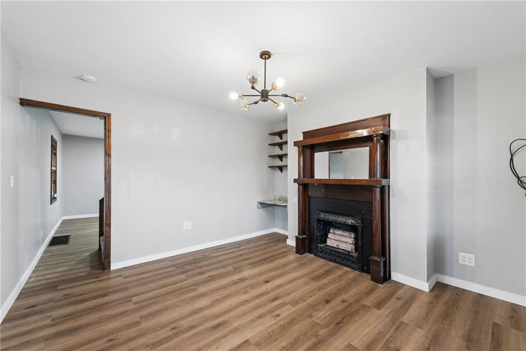 330 Braeburn Road Lower Burrell, PA 15068 - Photo 7 of 31 a view of an empty room with wooden floor fireplace and a window