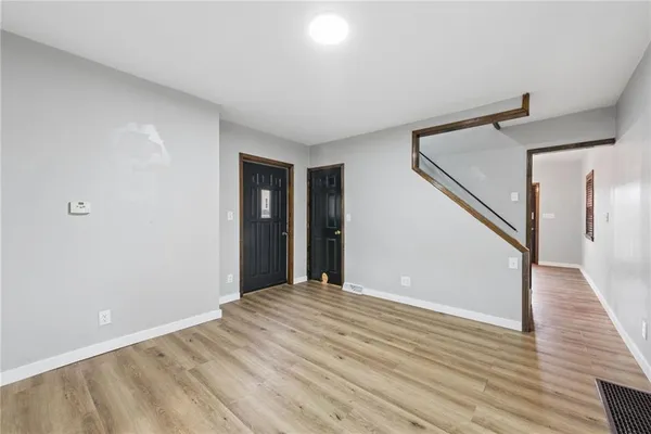 a view of a big room with wooden floor and stairs