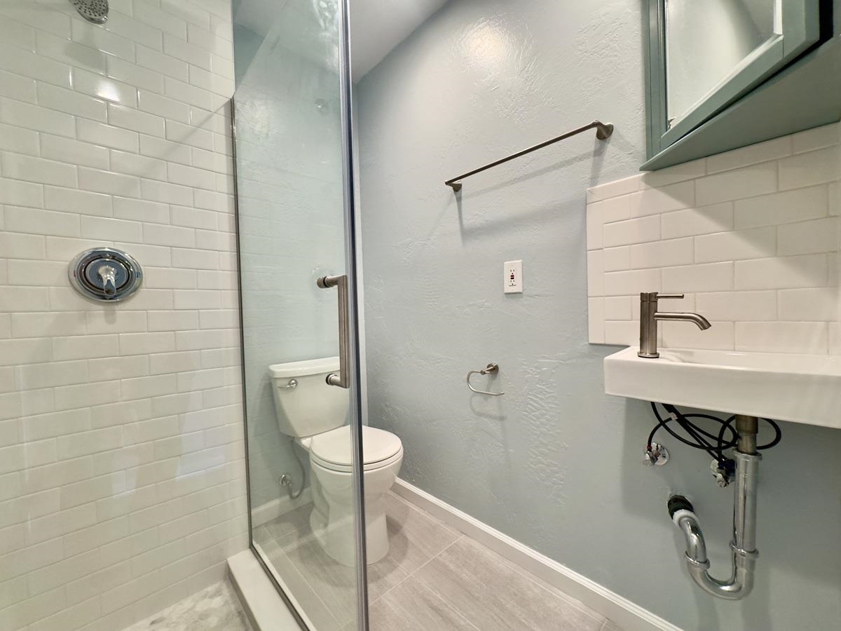 1022 Chestnut Street Oakland, CA 94607 - Photo 51 of 60 Bathroom featuring a textured wall, a tile shower, and tile patterned flooring
